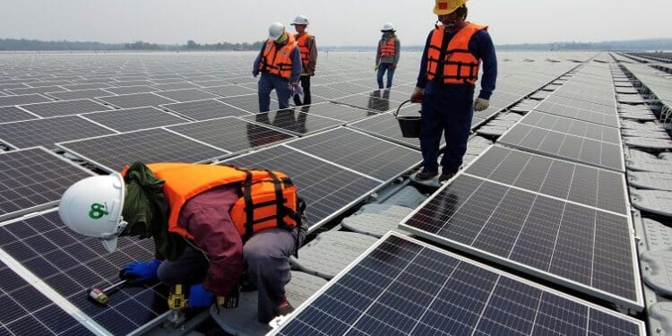A worker kneels by one of the solar cell panels over the water surface of Sirindhorn Dam in Ubon Ratchathani, Thailand April 8, 2021. Picture taken April 8, 2021 with a drone. REUTERS/Prapan Chankaew
